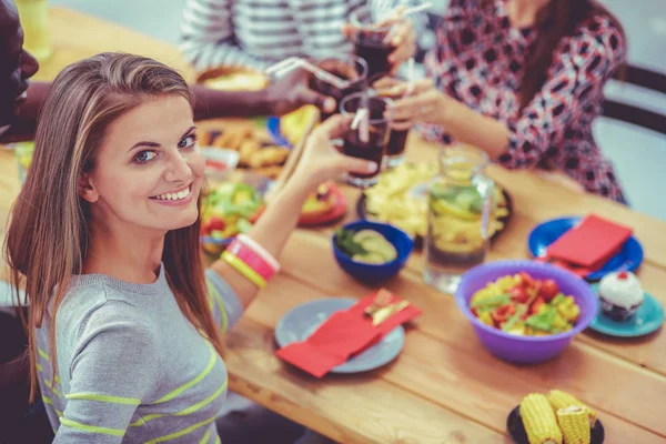 Draufsicht auf eine Gruppe von Menschen beim gemeinsamen Abendessen, während sie am Holztisch sitzen. Essen auf dem Tisch. Die Menschen essen Fast Food. Porträt eines Mädchens — Stockfoto