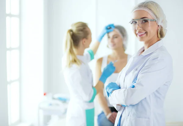 Schöne Frau Gesicht in der Nähe Arzt mit Spritze. — Stockfoto