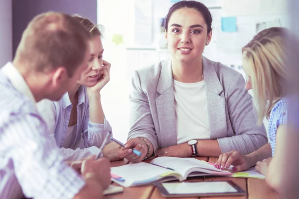 Junge Leute lernen mit Büchern auf dem Schreibtisch. Schöne Frauen und Männer arbeiten zusammen. — Stockfoto