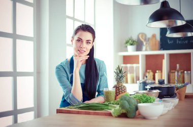 Mutfakta bir sepet taze sebzeyle genç.