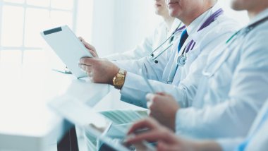 Tıbbi ekip masada oturup tartışıyor.