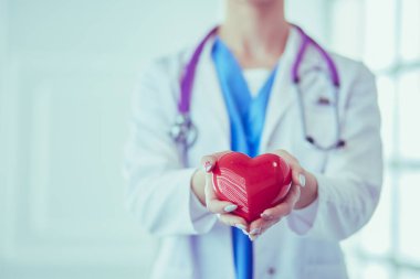 Kalbi tutan steteskoplu bir doktor, beyaz arka planda izole edilmiş.