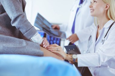 Doktor ve hasta tarama sonuçlarını tarama merkezinde tartışıyor