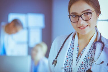 Hastane lobisinde tablet bilgisayar kullanan kadın doktor.