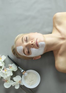 Yüz maskesi. Güzel genç kız Spa, makyajcısı kadın yüz maskesi uygulama.