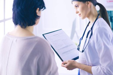 Güzel bayan doktor bir hastaya tıbbi tedaviyi açıklıyor.