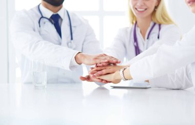 Doktorlar el ele tutuşup yakın çekim yapıyor.