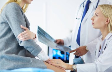 Doktor ve hasta tarama sonuçlarını tarama merkezinde tartışıyor