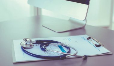 Tıbbi ekipman: Beyaz arka planda mavi steteskop ve tablet. Tıbbi ekipman