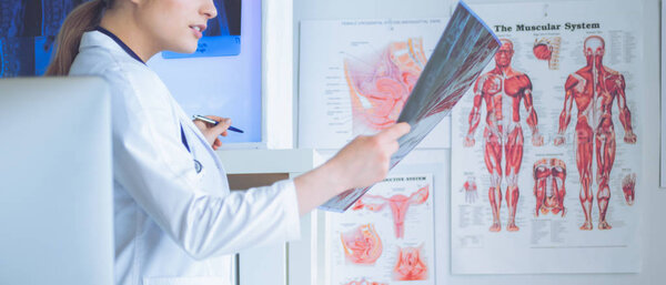 Молодая профессиональная женщина-врач осматривает пациентов рентгеном