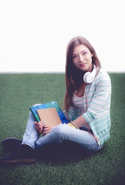 Yeşil çimlerde oturan genç bir kadın. Portreit genç bayan