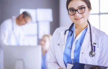Hastane lobisinde tablet bilgisayar kullanan kadın doktor.