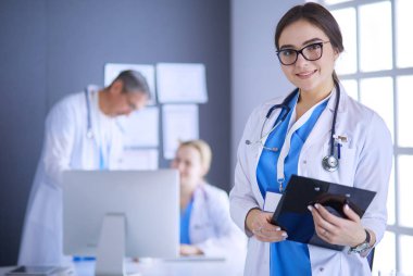 Hastane lobisinde tablet bilgisayar kullanan kadın doktor.