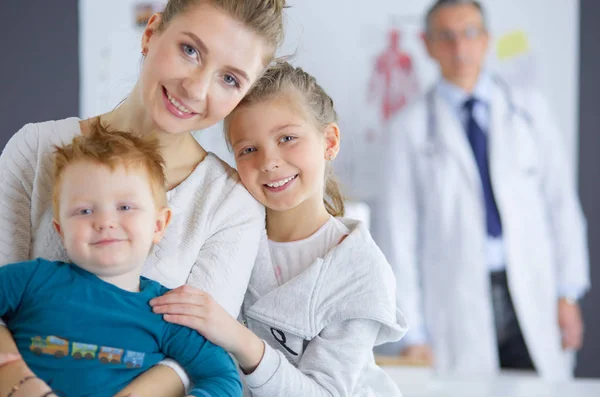 Маленькие дети с матерью на консультации у врача — стоковое фото