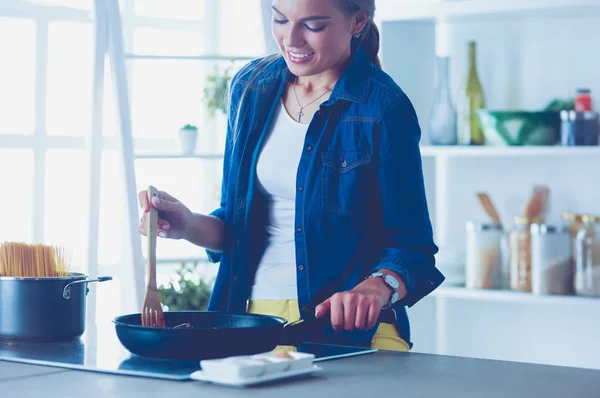 Молодая женщина на кухне готовит еду — стоковое фото