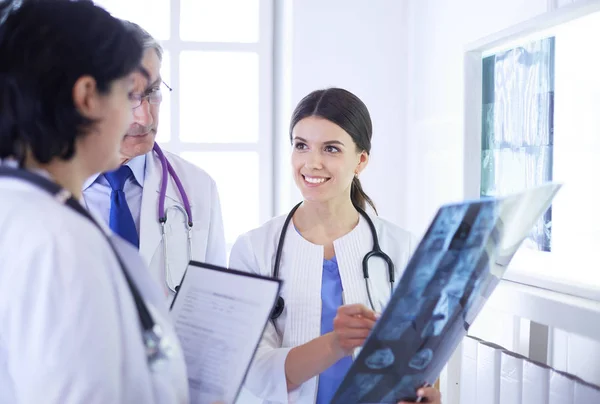 Médecins souriants discutant du diagnostic des patients regardant les rayons X dans un hôpital — Photo