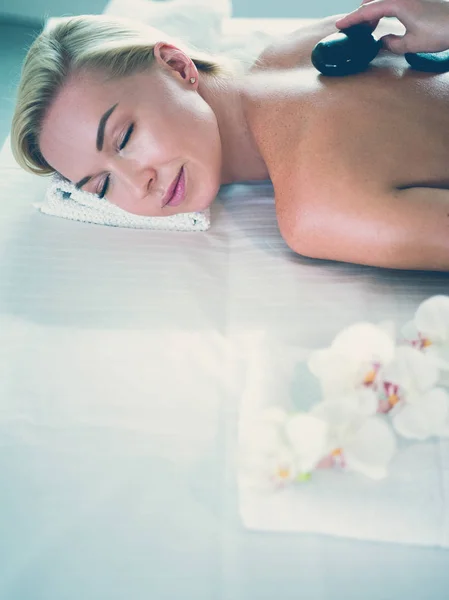 Young woman in spa salon, getting stones massage — Stock Photo, Image
