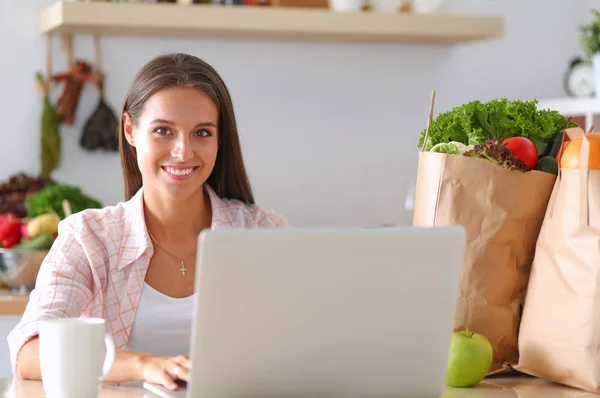 Smiling woman online shopping using tablet and credit card in kitchen . Smiling woman — Stock Photo, Image