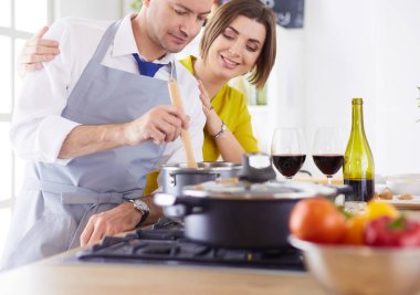 Aşık çekici bir çift yemek pişirir ve onlar romantik bir akşam yemeği pişirirken mutfakta şarap açar.