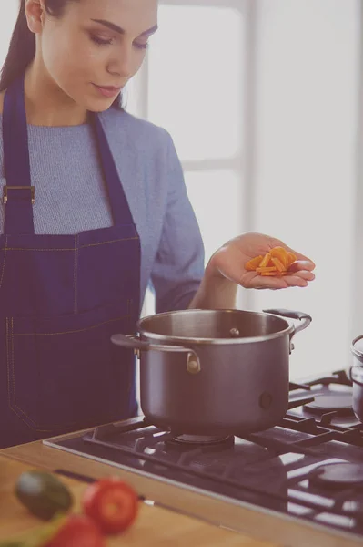 Cooking woman in kitchen with wooden spoon — Stock Photo, Image