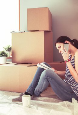 Kadın seçerek boya rengi renk örneği yeni ev ahşap yere oturmak için. Kadın evde