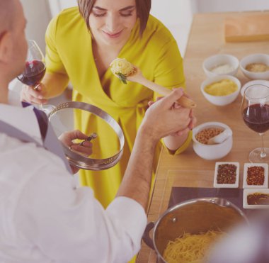 Evdeki mutfakta birlikte yemek pişiren çift.