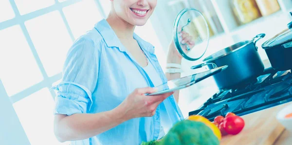 Giovane donna in piedi vicino al fornello in cucina — Foto Stock