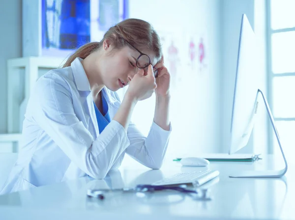 Retrato de uma jovem médica que sofre de dor de cabeça no trabalho — Fotografia de Stock