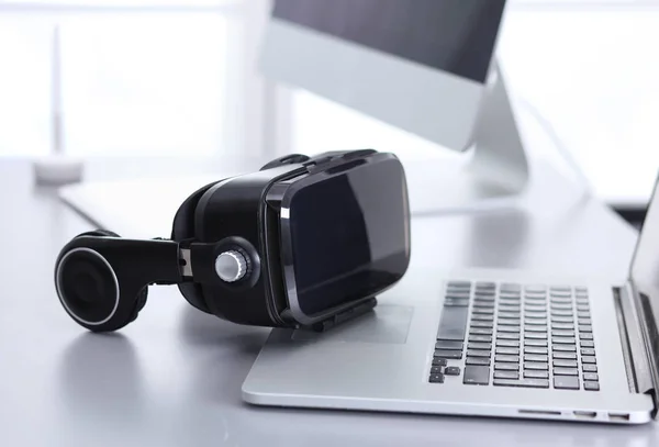 Virtual reality goggles on desk with laptop. business. 3d technology