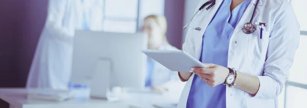 Médico femenino usando tableta en el vestíbulo del hospital —  Fotos de Stock