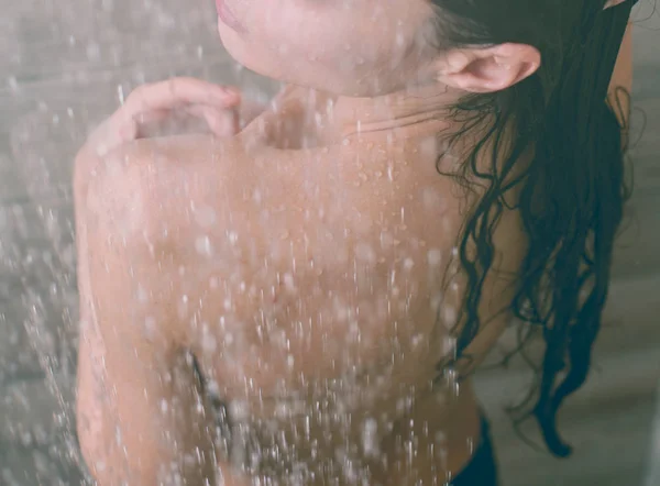 Joven mujer hermosa bajo la ducha en el baño . — Foto de Stock