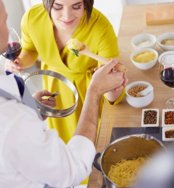 Evdeki mutfakta birlikte yemek pişiren çift.