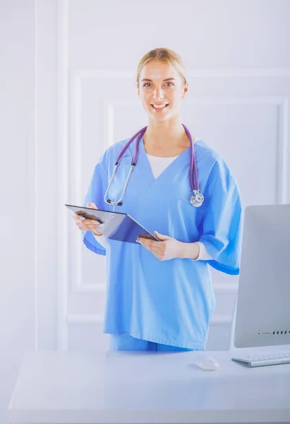 Smiling female doctor with a folder in uniform standing — Stock Photo, Image