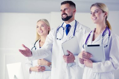 Meslektaşlarının önünde el sıkışan bir erkek doktor.