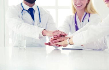 Doktorlar el ele tutuşup yakın çekim yapıyor.