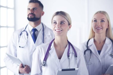Gülümseyen doktorlar çalışırken bir arada duruyorlar.