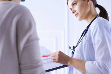 Güzel bayan doktor bir hastaya tıbbi tedaviyi açıklıyor.