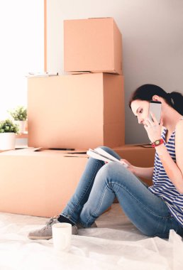 Kadın seçerek boya rengi renk örneği yeni ev ahşap yere oturmak için. Kadın evde