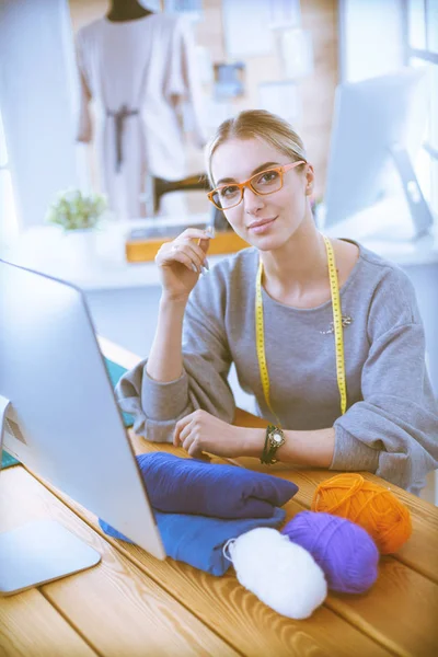 Fashion designer vrouw werken in de studio, zitten aan het bureau — Stockfoto