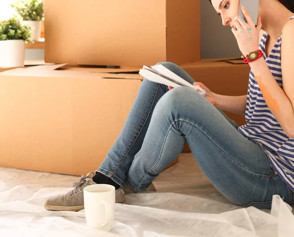 Γυναίκα επιλέγοντας βαφής από τη swatch για νέο σπίτι κάθεται στο ξύλινο πάτωμα. Γυναίκα στο σπίτι — Φωτογραφία Αρχείου