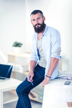 Çekici profesyonel işadamı evinde oturma odasında bir antrenör üzerinde oturan, onun laptop bilgisayar üzerinde çalışıyor