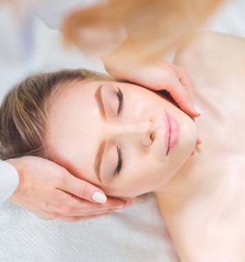 Masaj masasında uzanmış gözleri kapalı rahatlayan genç bir kadın. - Kadın. Spa salonu