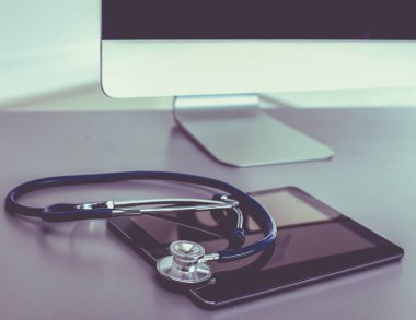 Tıbbi ekipman: Beyaz arka planda mavi steteskop ve tablet. Tıbbi ekipman