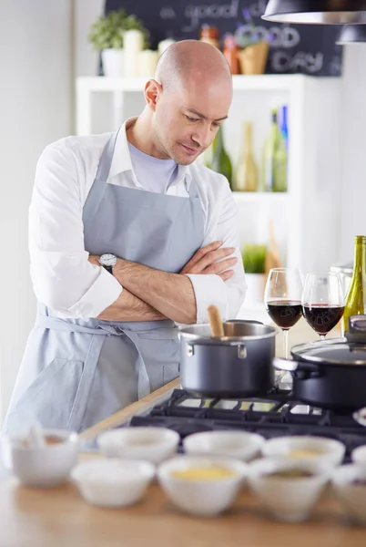 Handsome man is cooking on kitchen and smiling