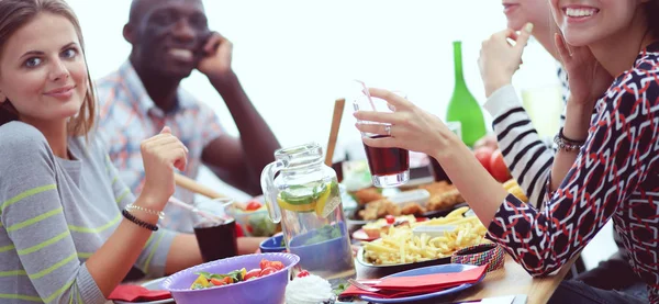 Draufsicht auf eine Gruppe von Menschen beim gemeinsamen Abendessen, während sie am Holztisch sitzen. Essen auf dem Tisch. Menschen essen Fast Food. — Stockfoto