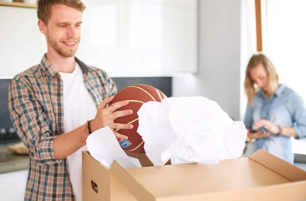 Couple unpacking cardboard boxes in their new home. Young couple. — Stock Photo, Image