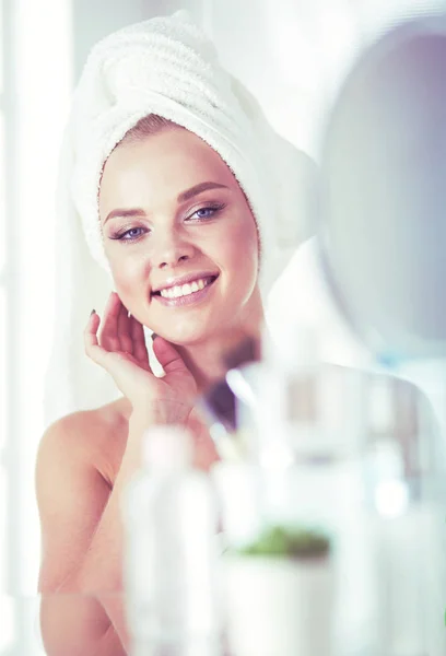Giovane donna in accappatoio guardando nello specchio del bagno — Foto Stock