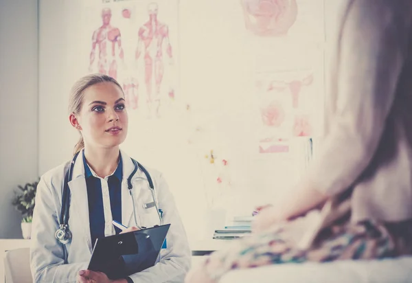 Dottore e paziente discutono di qualcosa mentre sono seduti al tavolo. Medicina e concetto di assistenza sanitaria — Foto Stock