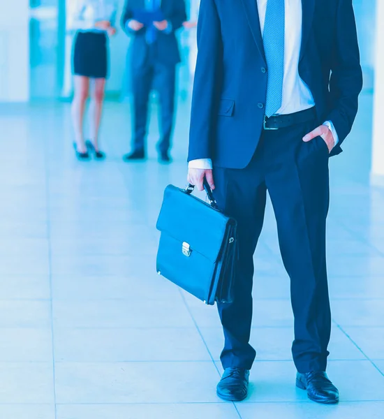 Porträtt av ung affärsman i office med kollegor i bakgrunden — Stockfoto