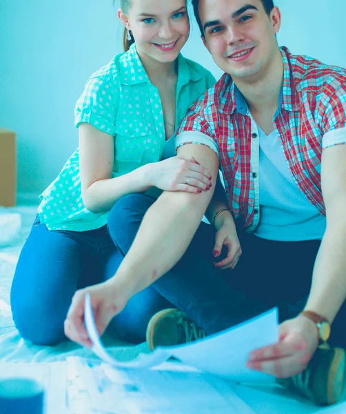 Young couple sitting on floor and calculating about they savings — Stock Photo, Image